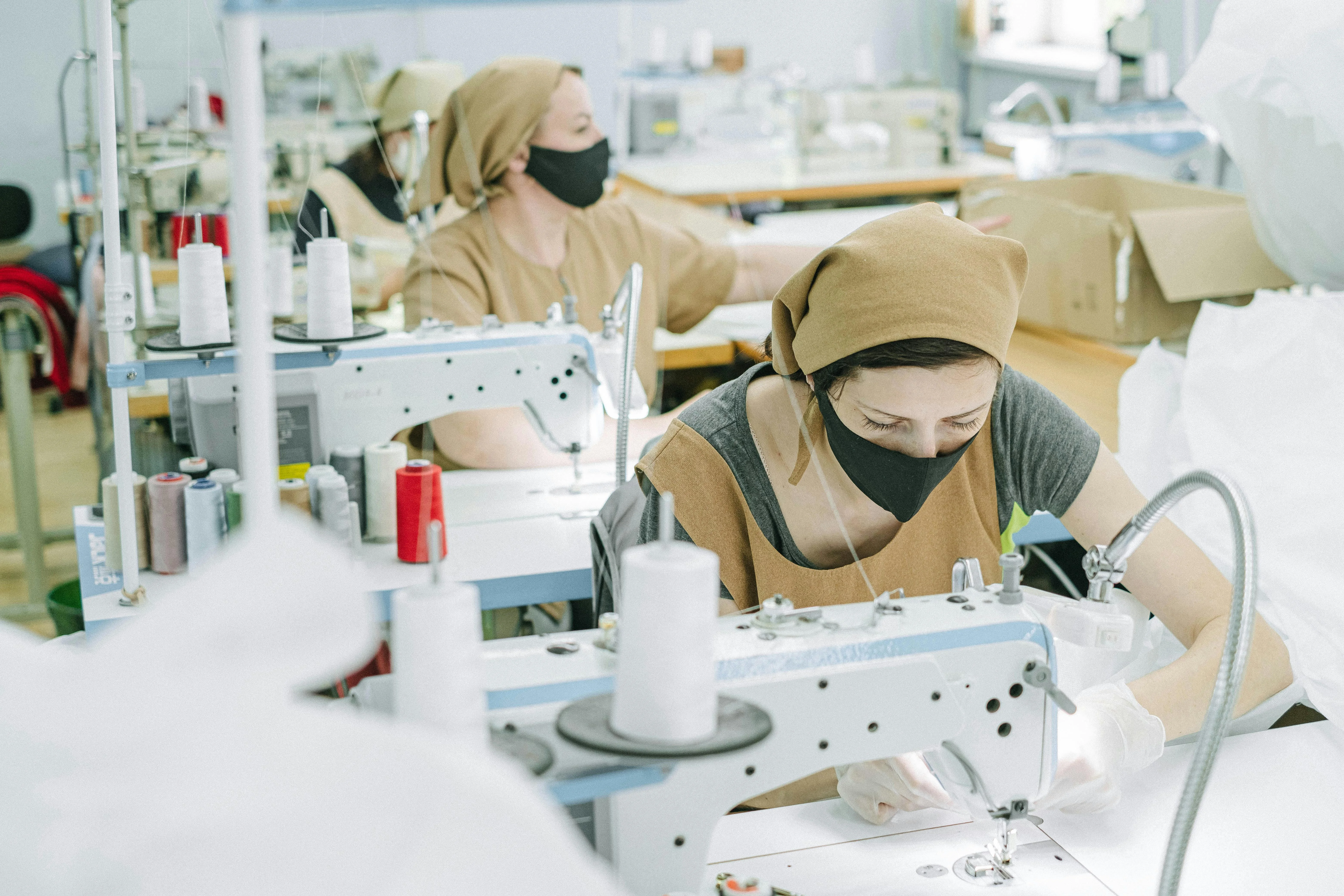 Skilled manufacturing operators working on textile production lines in an industrial facility.